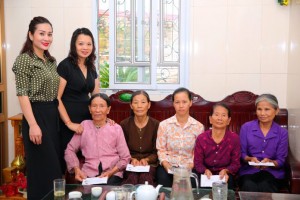 Hoa hậu Vũ Loan (bìa trái) trao quà thiện nguyện cho các mẹ