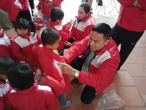 Nhà báo - MC Duy Mạnh đang mặc áo ấm cho các em nhỏ vùng cao