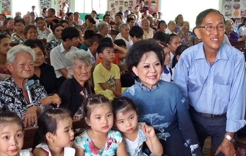Cca sĩ Giao Linh và ông Nguyễn Quốc Mỹ (hội trưởng Hội từ thiện Đất Việt) chụp với các bé là con em các gia đình trong Khu điều trị phong Bến Sắn