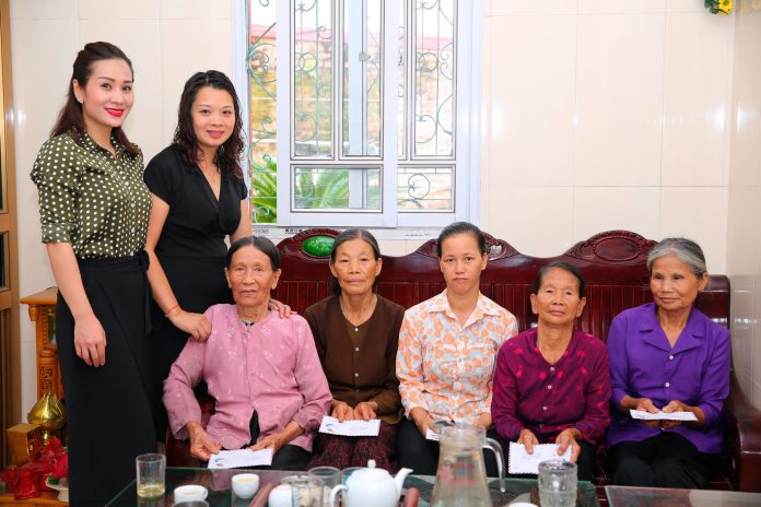 Hoa hậu Vũ Loan (bìa trái) trao quà thiện nguyện cho các mẹ