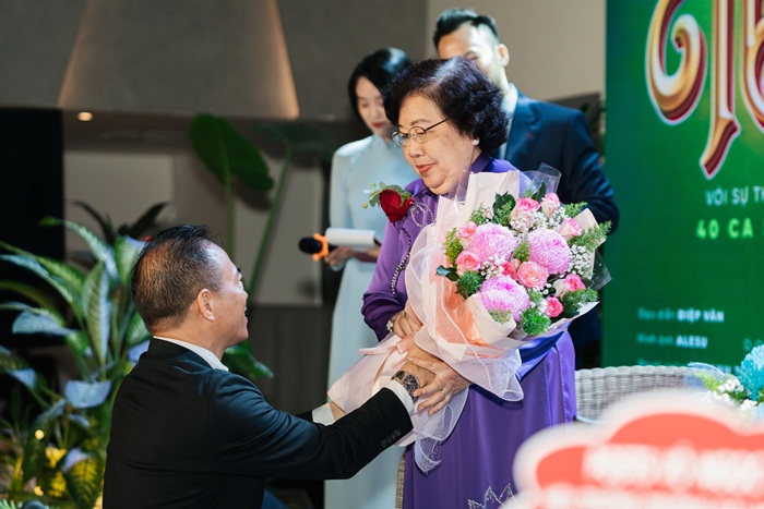 Tác giả Lê Long Sơn quỳ dâng hoa tặng cho thầy cô giáo cũ của mình là Cô Nguyễn Thị Hoài Thu (86 tuổi) và Thầy Nguyễn Đức Hoè (83 tuổi)