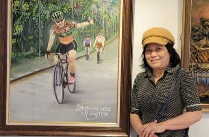 Họa sĩ Hồng TSN (Trương Thị Hồng) bên tác phẩm Về đích của chị